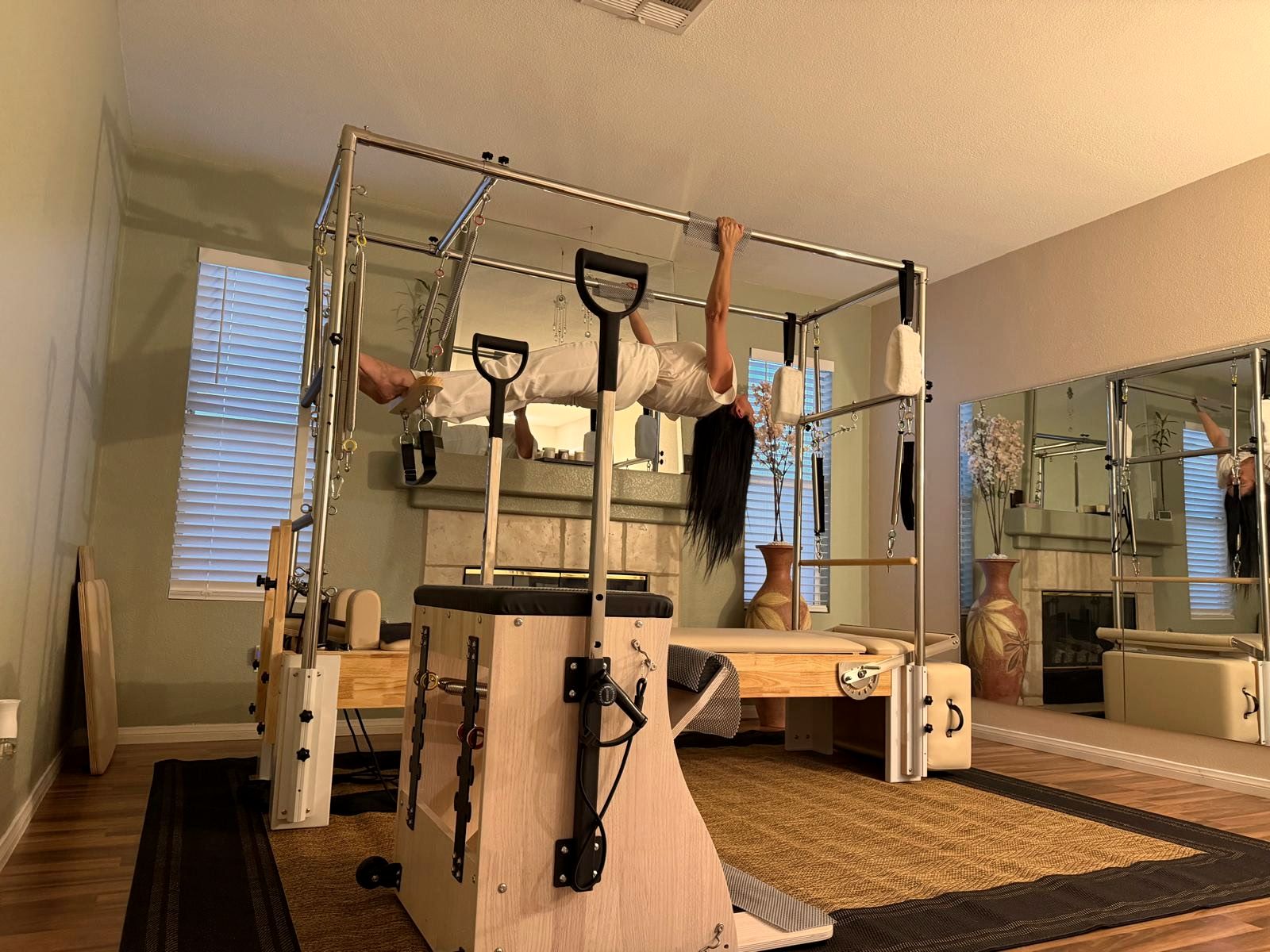 Eve Museri demonstrating an advanced hanging exercise on the Cadillac